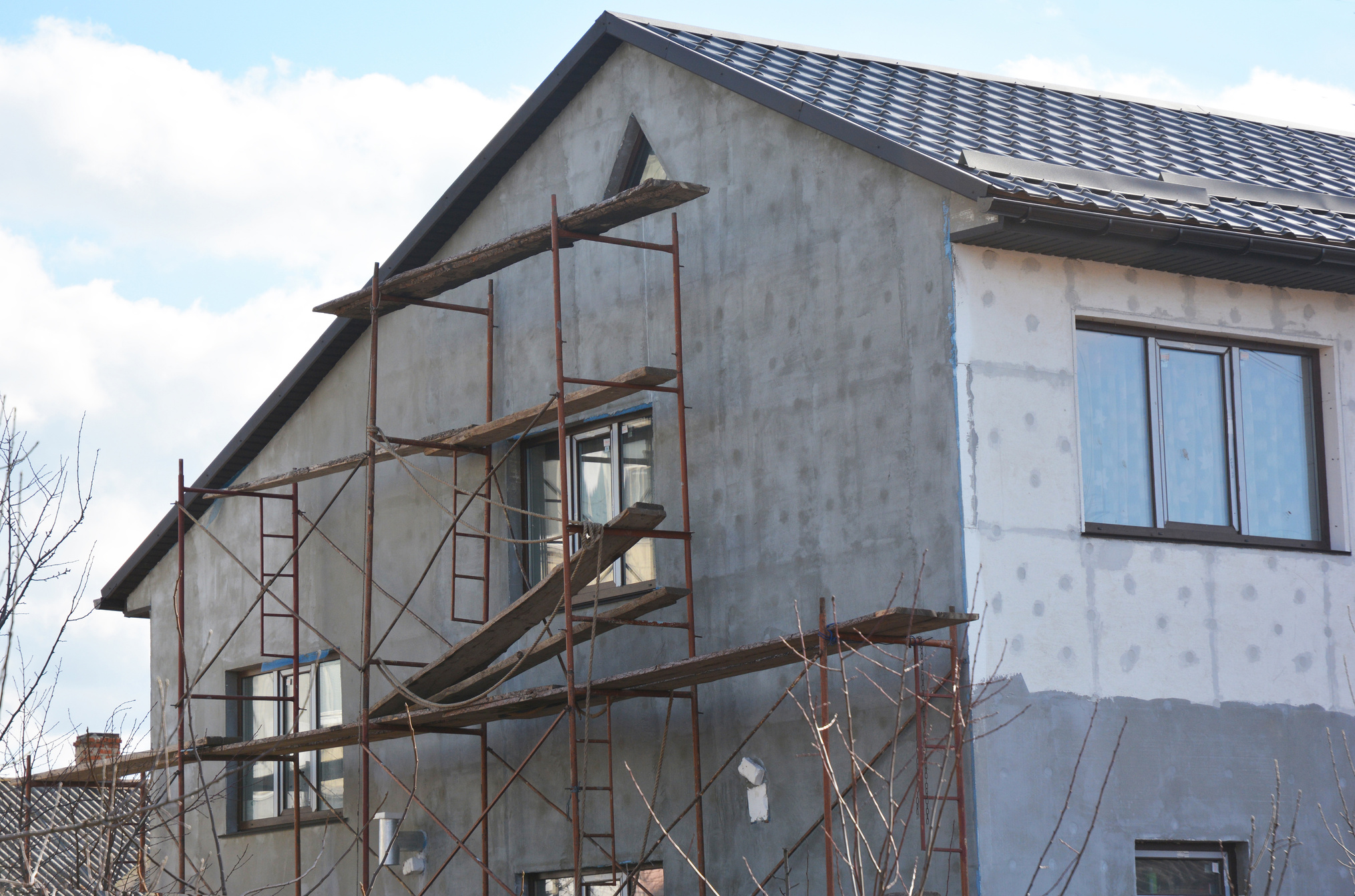 Painting, Plastering, Stucco  and insulate Exterior House Wall. Facade Thermal Insulation and Painting Repair Works During Exterior Renovations. Wall Insulation and Repair.